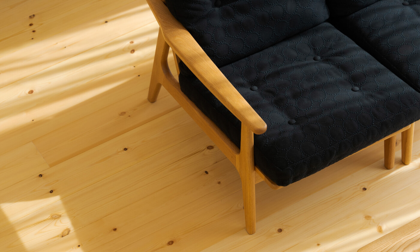 イメージ：木目の見える床と木材が使われた黒いソファ