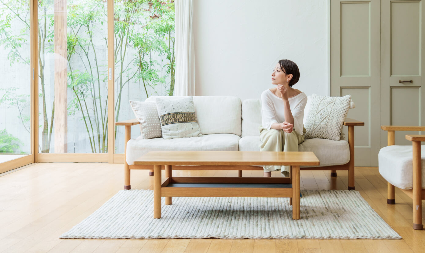イメージ：明るい窓とソファに座る女性